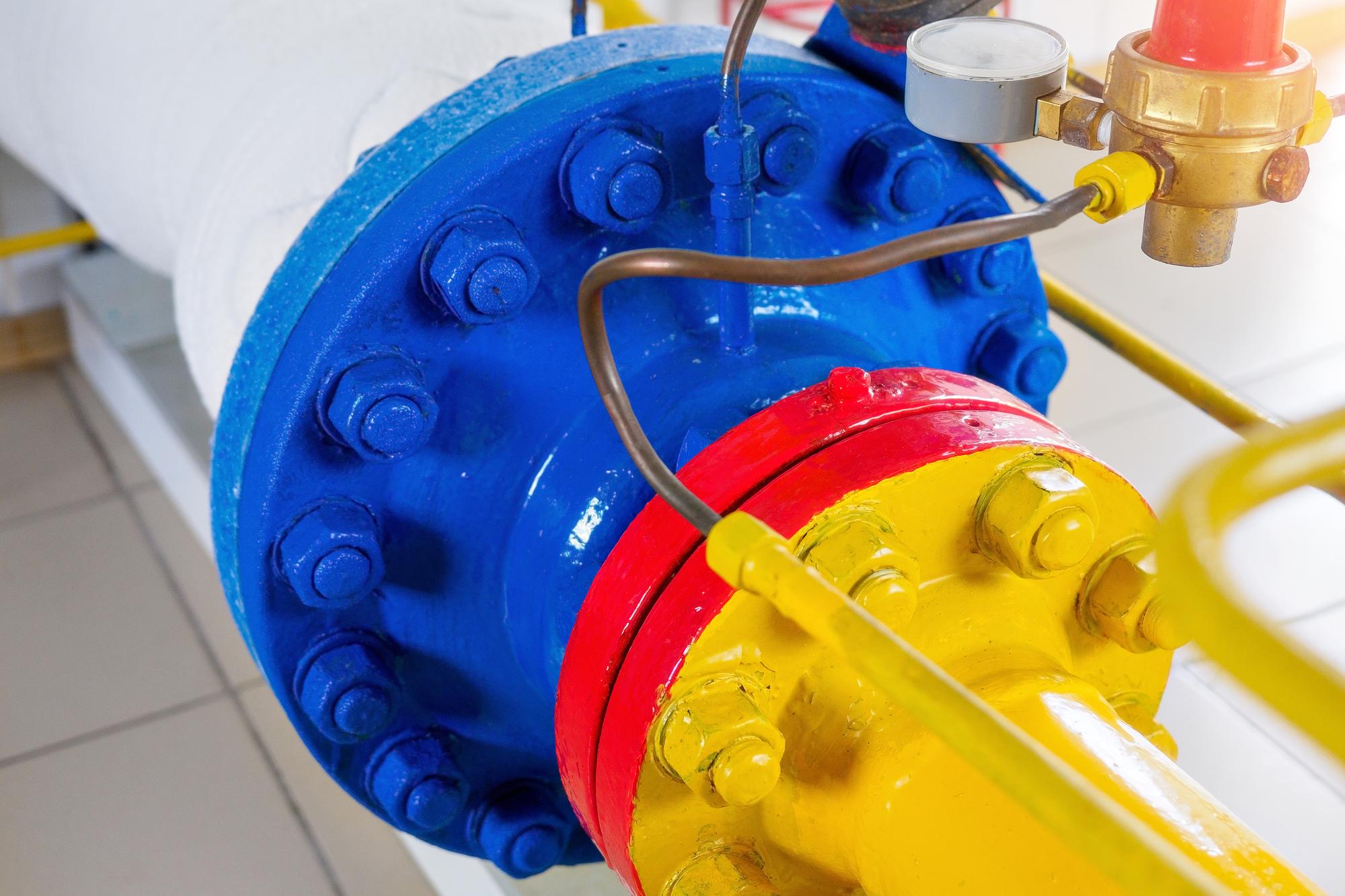 Os parafusos de metal dos tubos são pintados com tinta amarela vermelha e azul Parte do equipamento de gaseificação Fundo industrial